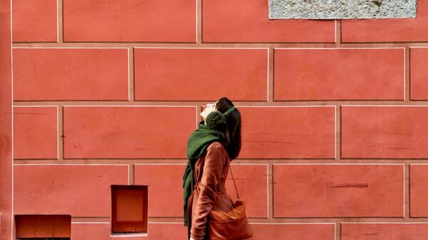person in brown leather jacket standing in front of brown brick wall
